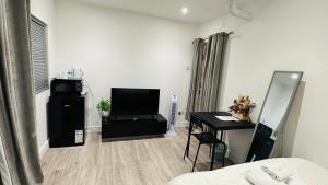 a living room with a bed and a table and a television at COSY AND COMFY DOUBLE ROOM in London