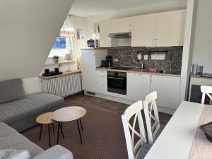 a living room with a couch and a kitchen at Löwenstein Ferienwohnungen in Willingen