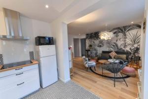 a kitchen and a living room with a table at Marché Arago (3min), plage (8min), jardin clos. in Les Sables-dʼOlonne