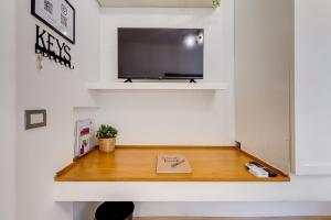 a room with a desk with a tv and a book at Aventino Industrial Loft in Rome