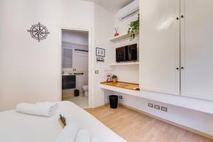 a white room with a bed and a kitchen at Aventino Industrial Loft in Rome