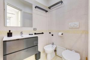 a bathroom with a sink and a toilet and a mirror at Aventino Industrial Loft in Rome