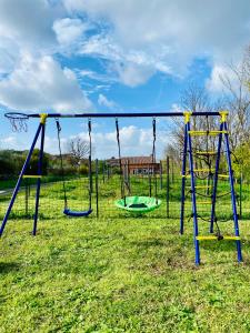 une aire de jeux avec trois balançoires dans un champ dans l'établissement Villa Bubù, Appartamento Country-chic, à Rome 47 autres photos