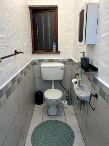 a bathroom with a toilet and a sink at Meet U at the Beach in Hibberdene