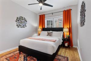 フィラデルフィアにあるFitler Square GEM - 3 Bedroomsのベッドルーム1室(大型ベッド1台、オレンジ色のカーテン付)