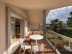 einen Balkon eines Hauses mit einem Tisch und Stühlen in der Unterkunft Golden Dunes Apartment in Porto Pino