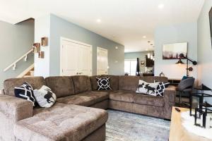 a living room with a brown couch in a room at Modern Home - King Bed - Garage - Long Stays in Edmonton