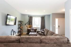 a living room with a large couch and a chair at Modern Home - King Bed - Garage - Long Stays in Edmonton