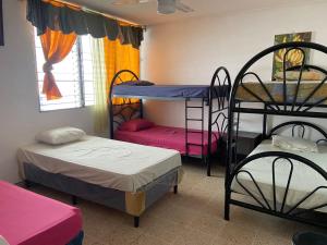 Ένα ή περισσότερα κρεβάτια σε δωμάτιο στο Hostal Cumbres de El Salvador +55 φωτογραφίες