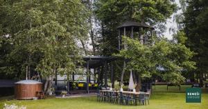een tuinhuisje met tafels en stoelen in een park bij Atpūtas vieta Remeši 