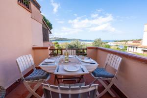 a wooden table and chairs on a balcony at Marinella-Porto Rotondo, Accesso Diretto sulla SPIAGGIA in Porto Rotondo