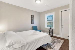 a bedroom with a white bed and a blue chair at Comfy Home Near Downtown Detroit in Detroit