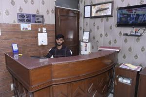 a man sitting at a counter in a barber shop at Hotel Royal Inn in New Delhi