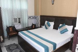 a bedroom with a large bed with blue and white pillows at Hotel Royal Inn in New Delhi