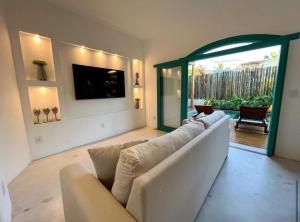 a large living room with a couch and a television at Flô Casa Hotel in Trancoso