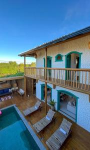 a house with a deck and a swimming pool at Flô Casa Hotel in Trancoso