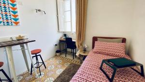 ein kleines Schlafzimmer mit einem Bett und einem Schreibtisch in der Unterkunft Free Breakfast, Pool, Spacious Aircon Hideaway in Mosta