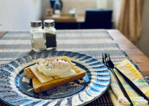 eine blaue und weiße Platte mit einem Stück Brot mit Schlagsahne in der Unterkunft Free Breakfast, Pool, Spacious Aircon Hideaway in Mosta