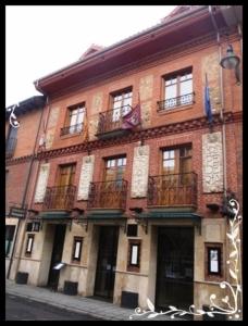 un gran edificio de ladrillo con balcones en una calle en Hospederia Fernando I en León