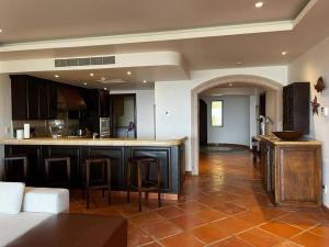 a kitchen with an island in a living room at Hermoso y Exclusivo Departamento in Cabo San Lucas