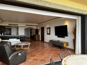 a living room with a couch and a tv at Hermoso y Exclusivo Departamento in Cabo San Lucas