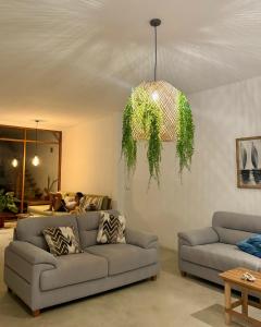 a living room with a couch and a chandelier at Casa GAIA - Punta Sal in Canoas De Punta Sal