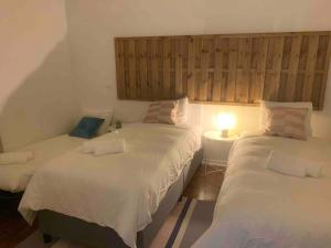 - une chambre avec deux lits et une lampe sur une table dans l'établissement Carcavelos Maristas BEACH pax5, à Carcavelos