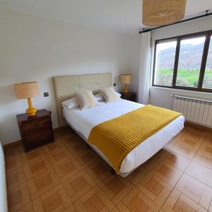 a bedroom with a large bed with a yellow blanket at MIRADOR PIE DE LA SIERRA in Llanes