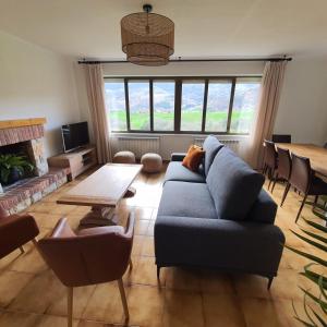 ein Wohnzimmer mit einem blauen Sofa und einem Tisch in der Unterkunft MIRADOR PIE DE LA SIERRA in Llanes