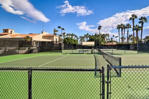 two tennis courts with palm trees in the background at Palm Desert Condo with Patio and Community Perks! in Palm Desert