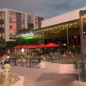 un restaurante con mesas y sombrillas frente a un edificio en Playa Vista Bedroom Retreat!, en Glendale
