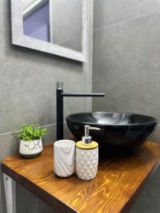 a bathroom with a black sink on a wooden counter at GuestHouse "Shtëpia ime" in Përmet