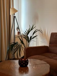 una sala de estar con una mesa con una lámpara y una planta en GuestHouse "Shtëpia ime" en Përmet