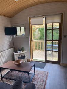 a living room with a table and an open door at Letterkenny Cabin in Letterkenny