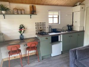 cocina con 2 taburetes y barra en una habitación en Letterkenny Cabin en Letterkenny