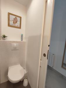 a bathroom with a white toilet and a door at Studio Beauvais in Beauvais