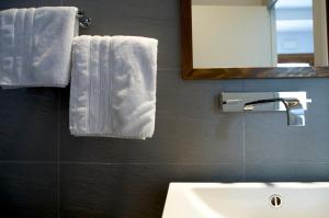 a bathroom with white towels and a sink and a mirror at Hotel Los Patios - Parque Natural in Rodalquilar