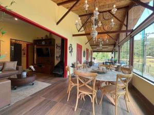 - une salle à manger et un salon avec une table et des chaises dans l'établissement Sítio incrível com piscina e lago, à Nova Friburgo