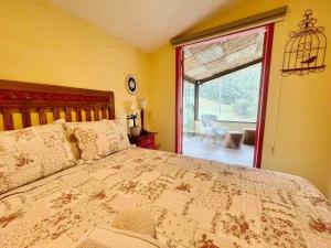 - une chambre avec un lit et une grande fenêtre dans l'établissement Sítio incrível com piscina e lago, à Nova Friburgo
