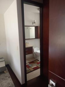 a bathroom with a toilet and a sink at Habitación central con balcón, baño privado y parqueadero in Duitama