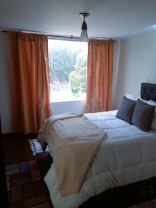 a bedroom with a large bed in front of a window at Habitación central con balcón, baño privado y parqueadero in Duitama +3 photos