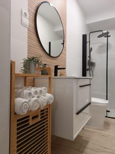 a bathroom with a mirror and a shelf with towels at CASA VENERA in Orgaz