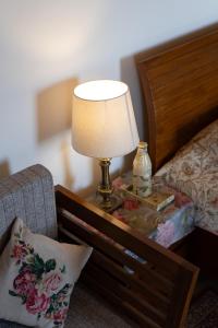 a lamp on a table next to a bed at Eden Estate Cottages x THHPlife - Mashobra in Mashobra