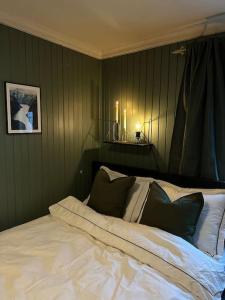 ein Schlafzimmer mit einem weißen Bett und schwarzen Kissen in der Unterkunft Koselig hytte, nær Finnskogen og Vålerbanen in Åsnes