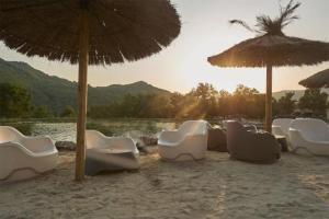 un grupo de sillas y sombrillas en una playa en Maisons situées dans le vaste domaine de l'espinet en Quillan