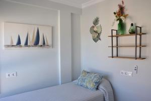 a bedroom with a bed and a shelf with boats on the wall at Nuevo frente al mar, wifi 600 in Benalmádena