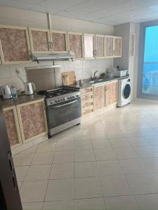 a large kitchen with a stove and a dishwasher at F30,R4,Single Room on the beach attach bath in Ajman 