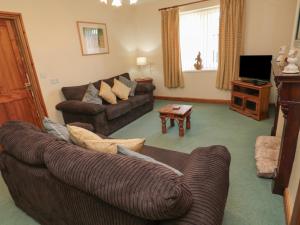 a living room with a couch and a television at The Retreat in Alnwick