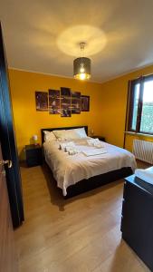 una camera da letto con un grande letto con pareti gialle di Sandy Apartment a Sirmione
