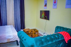 een woonkamer met een blauwe bank en een tafel bij The Sunset Home's in Mombasa